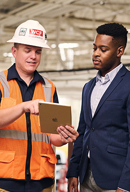 Business owner with safety representative discussing workers' compensation and safety.